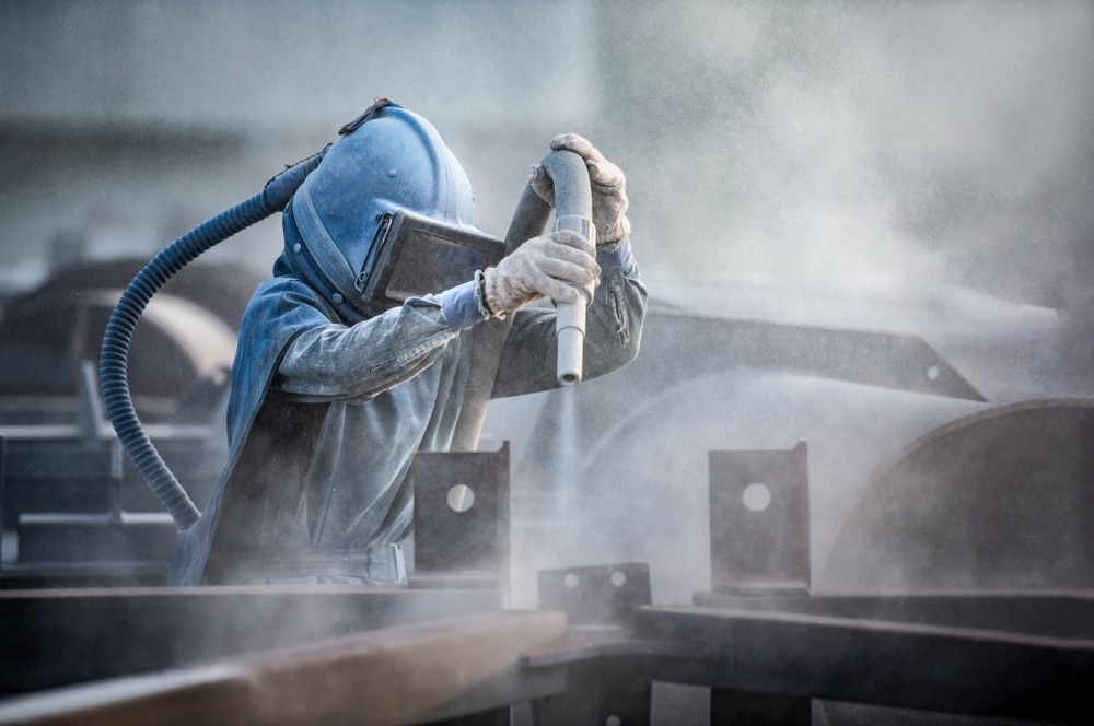 man painting heavy equipment