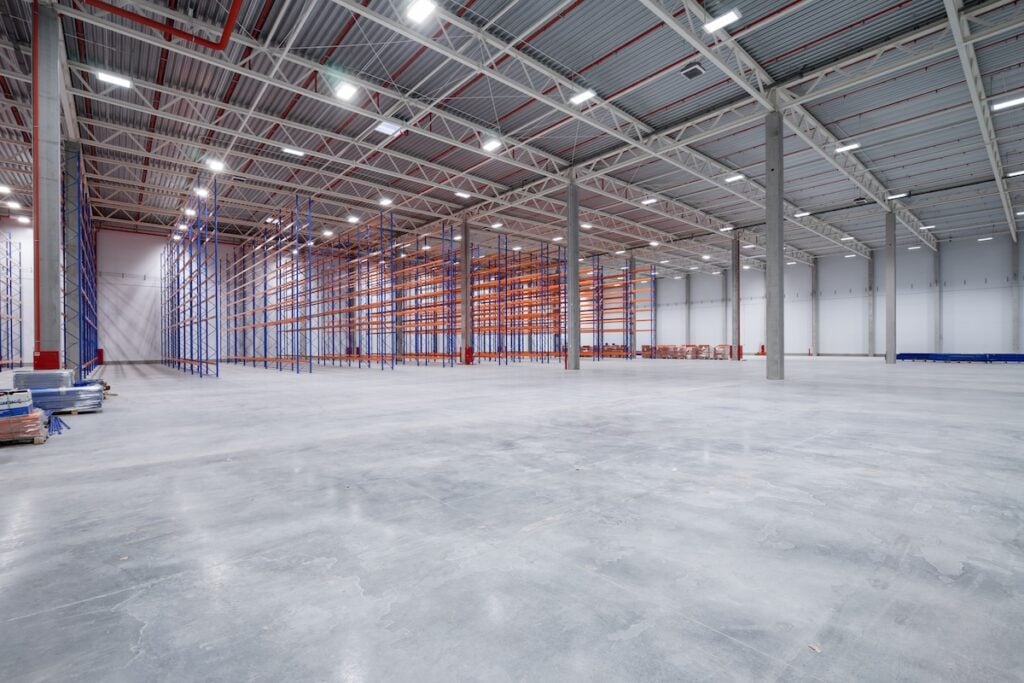 concrete floor finishes warehouse or hangar. Industrial building interior consist of polished concrete floor and closed door for product display or industry background.