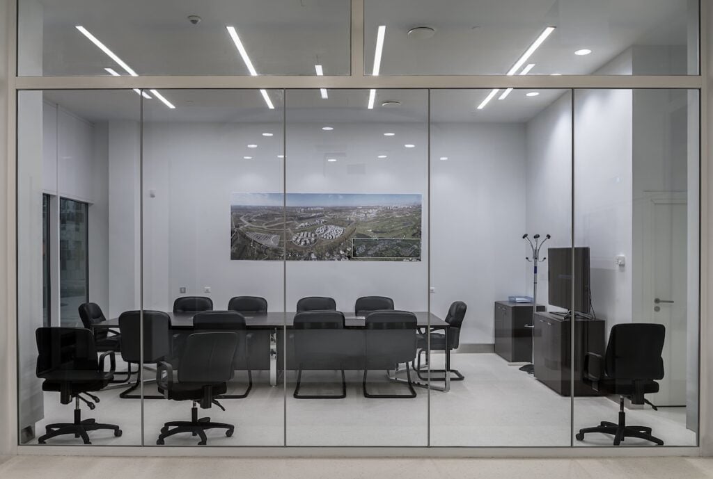 how to soundproof a room from outside noiseA modern meeting room with transparent partitions, with a large table and comfortable office chairs. 
