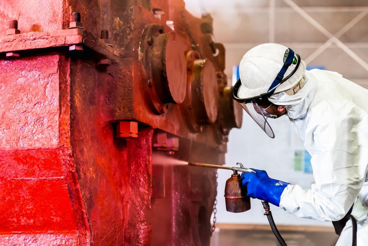 Rust Prevention Paint worker paiting red heavy gear machine steel structure surface by airless spray gun