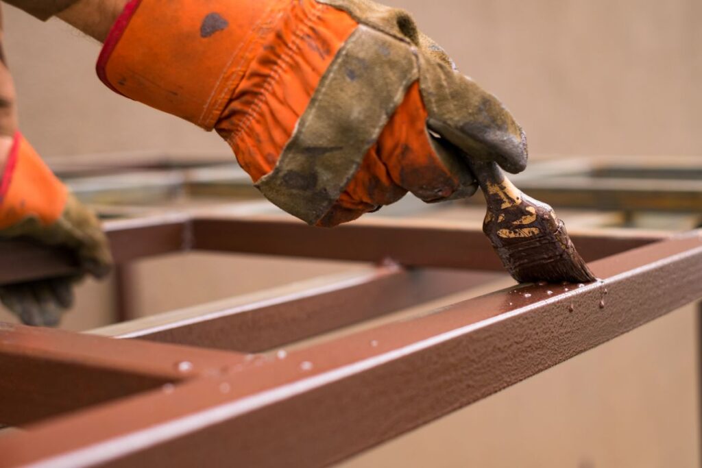 fire resistant paint for metal close up hand painting with paint brush metal construction brown