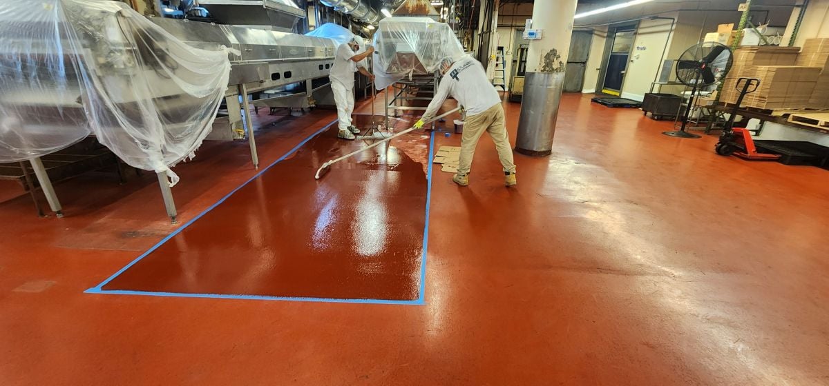 food grade paint workers applying epoxy on floor inside facility