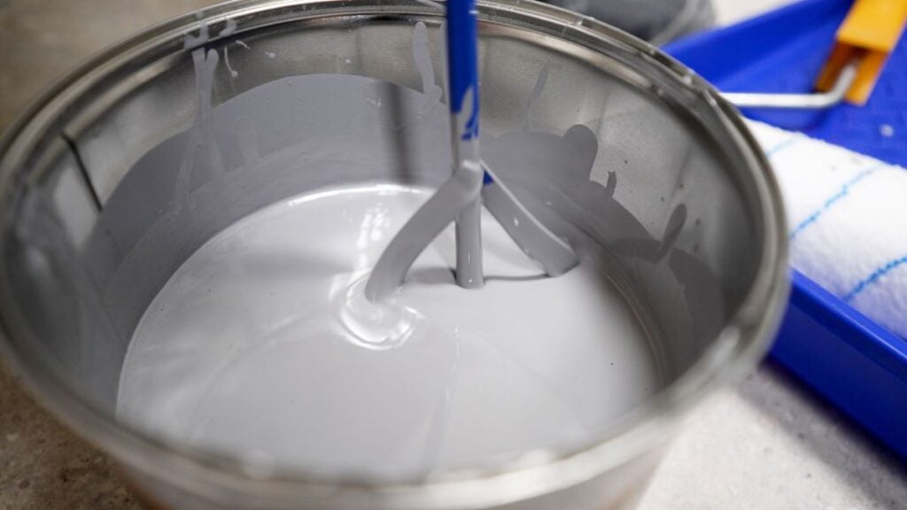 rust prevention paint close up worker mixing grey paint in can