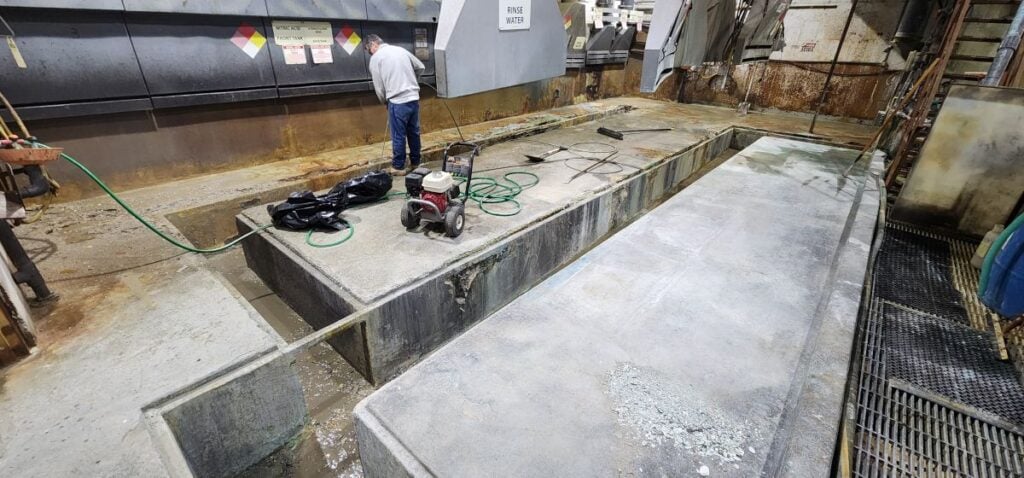 what type of sand is used for sandblasting McLean Company worker cleaning surface with hydraulic hose