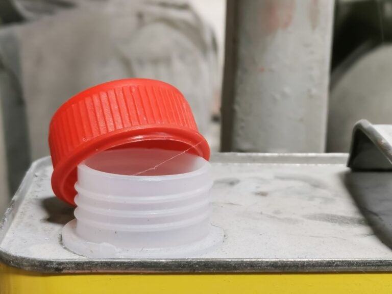 Close up image plastic red cap of thinner canned against blurry background