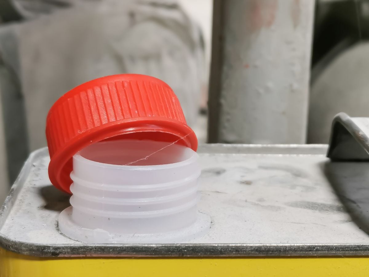 Close up image plastic red cap of thinner canned against blurry background