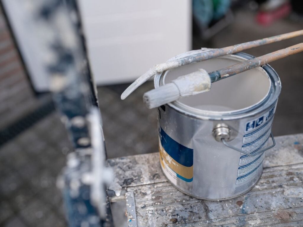 White no VOC paint bucket with brush resting on rim
