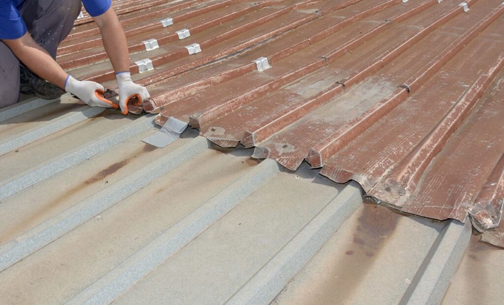 roofer inspecting an old and rusty metal roof