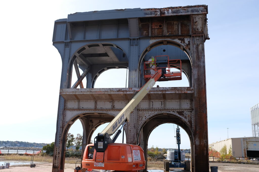 industrial painting services blue structure worker removing rust