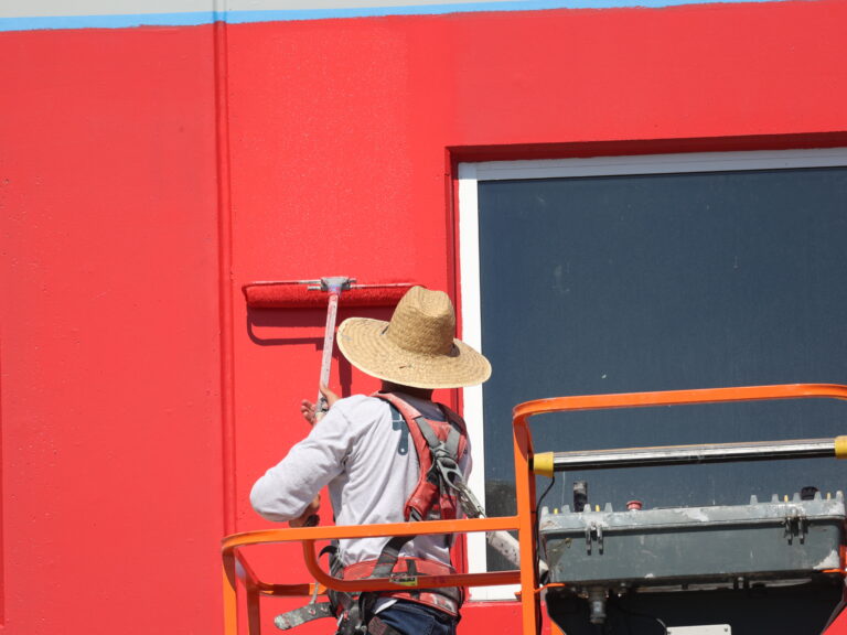 industrial painting services McLean worker painting red house