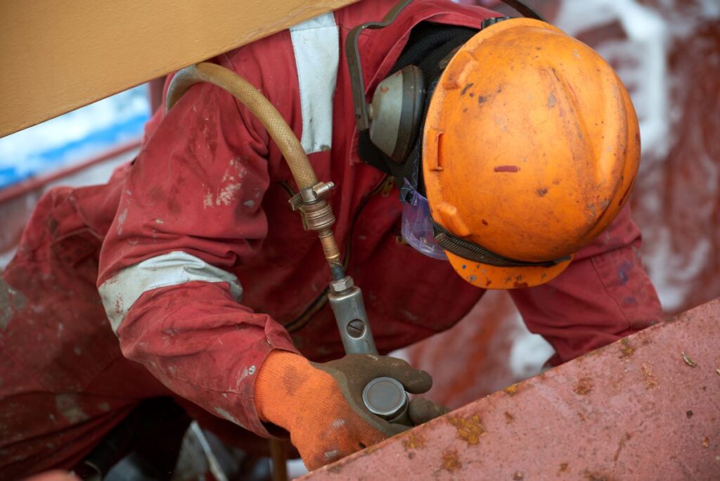 rust inhibitor worker using tool to remove rust