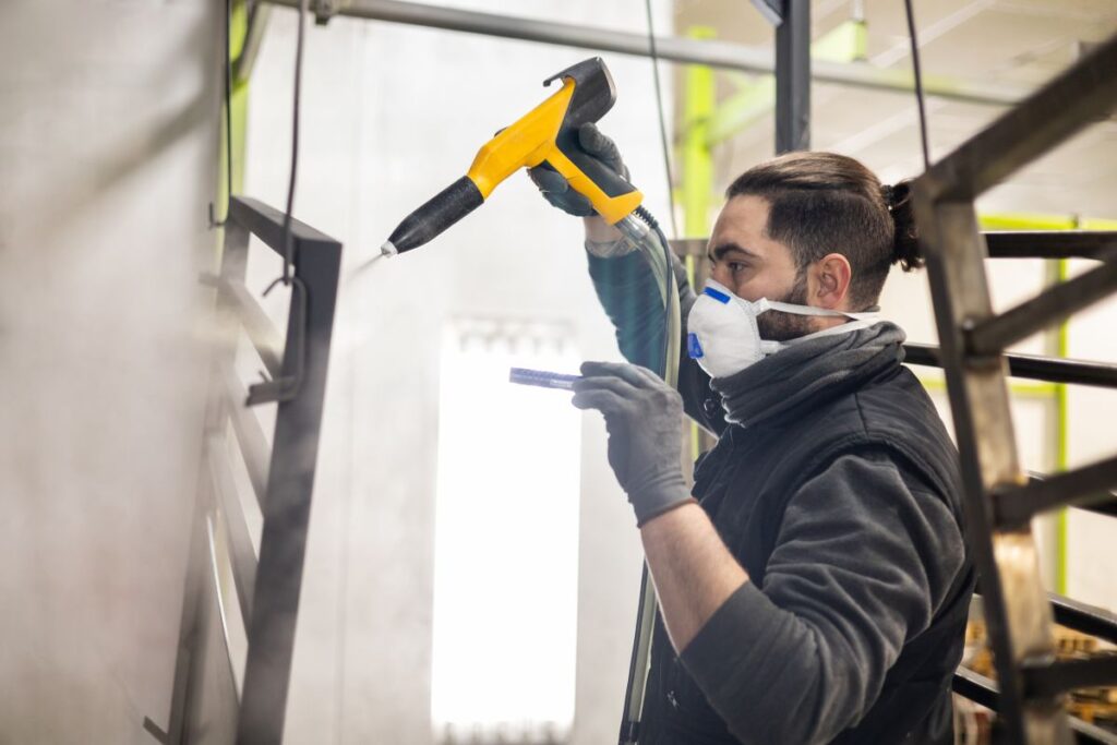 what is powder coating worker using gun on metallic parts