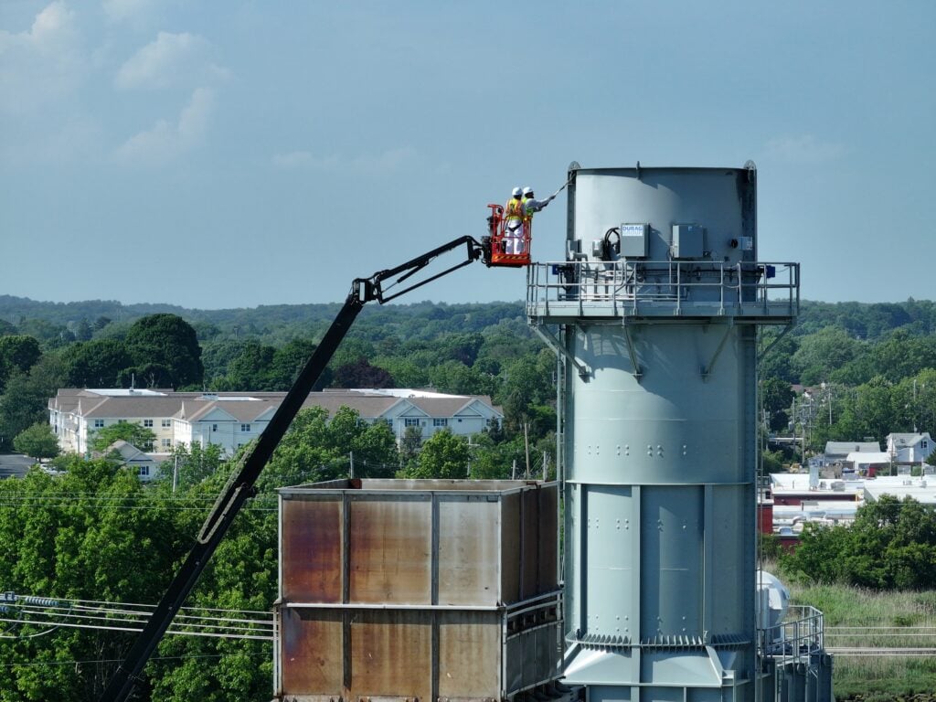 fire resistant paint aerial view of worker painting big tank outside facility