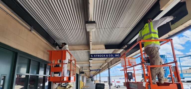 how much do painters charge per square foot two workers standing on elevated platform using red paint workers painting blue station