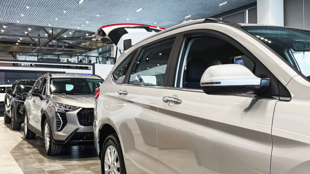 car dealership flooring Several cars are lined up in a dealership showroom. The area is busy with visitors looking at the vehicles.
