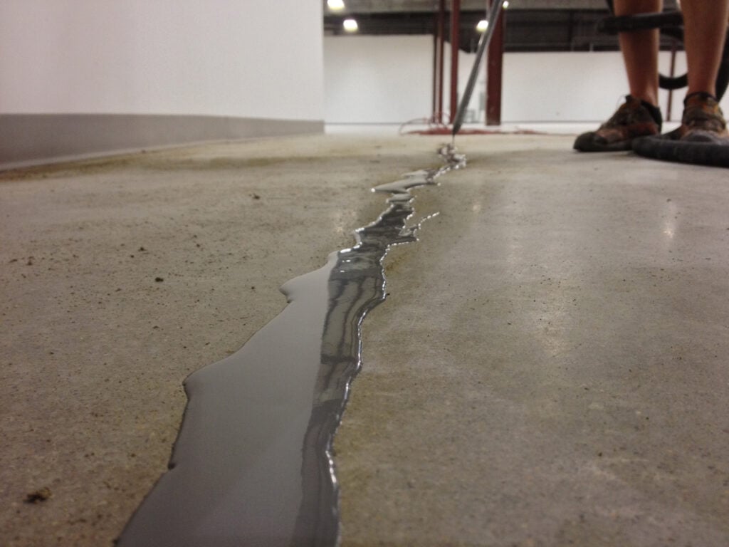 commercial expansion joint repair worker filling joint